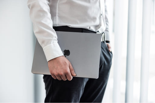 Tobias Lechner hält ein MacBook Pro von Lechner IT-Dienstleistungen in seiner rechten Hand.